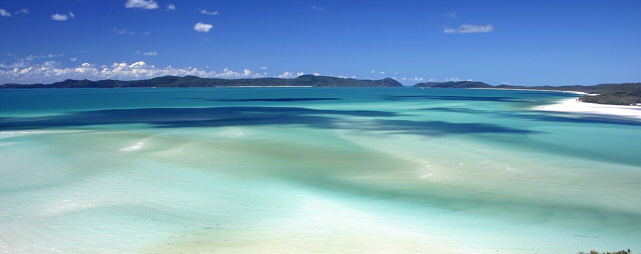 Turquoise sea swirling into white sand